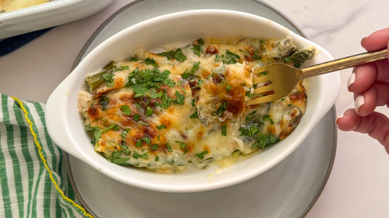 Fork removing bite of asparagus casserole