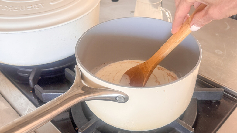 hand stirring cream in pot