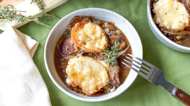Cheesy French onion pot roast in serving bowls with fresh thyme