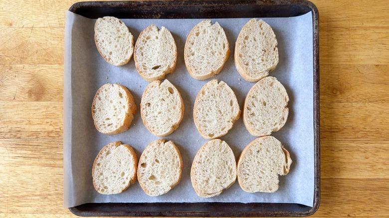 Baguette slices on small baking tray lined with parchment paper