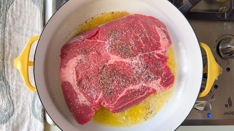 Boneless beef chuck roast in large pot with butter and olive oil