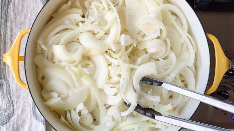 Sliced yellow onions in large pot on stovetop