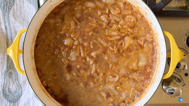 Caramelized onions and broth in large pot on stovetop