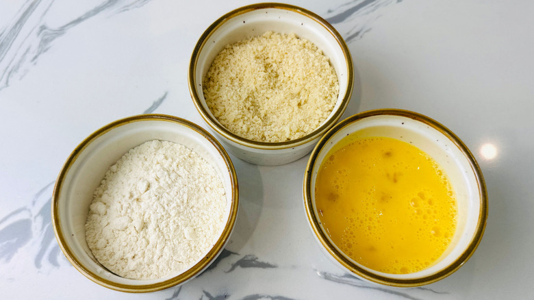 Bowls of flour, breadcrumbs, and egg