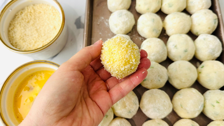 Hand holding breaded mashed potato ball