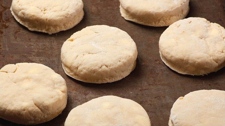 Close-up of unbaked biscuits on a metal sheet pan