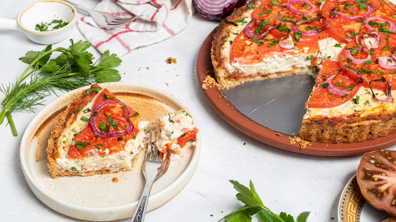 Roasted tomato pie with a slice cut out on a plate and a fork with piece of the pie