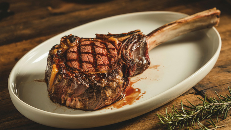 Grilled Tomahawk steak on white plate