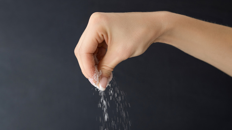 An individual sprinkling salt.