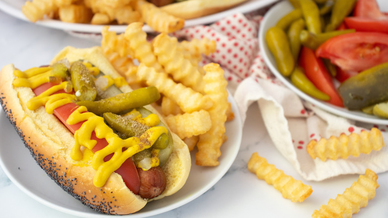 Side shot of several Chicago-style hot dogs and toppings