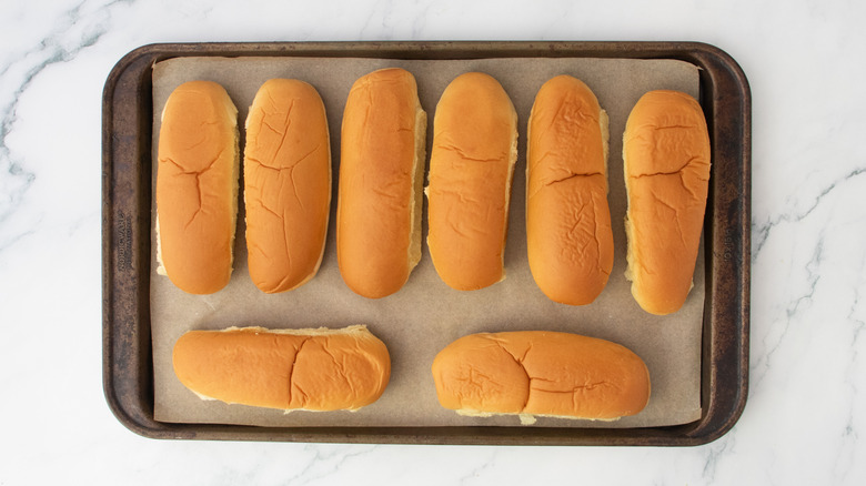 Hot dog buns on a large baking sheet