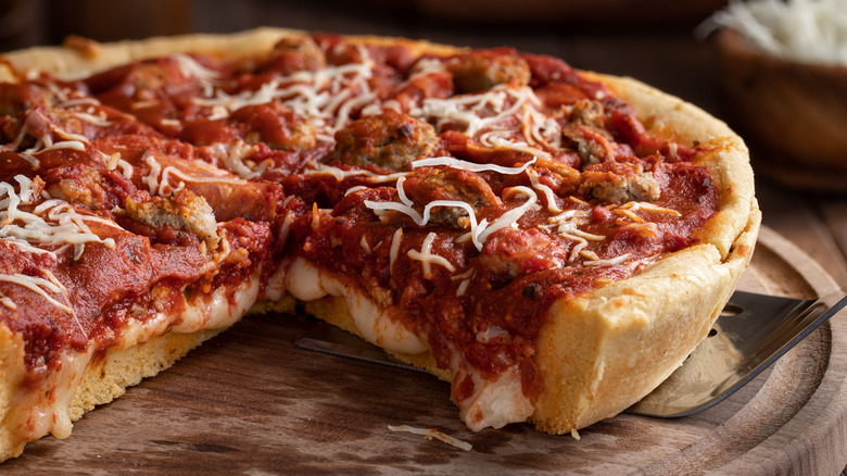 A deep dish pizza sliced
