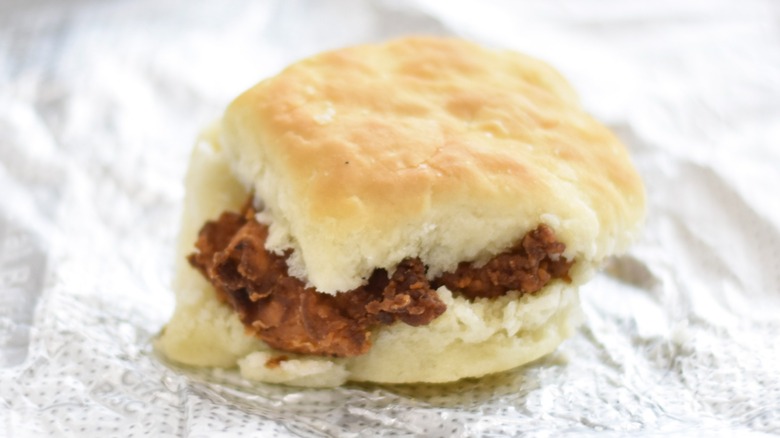 A spicy Chick-fil-A chicken biscuit on a foil wrapper