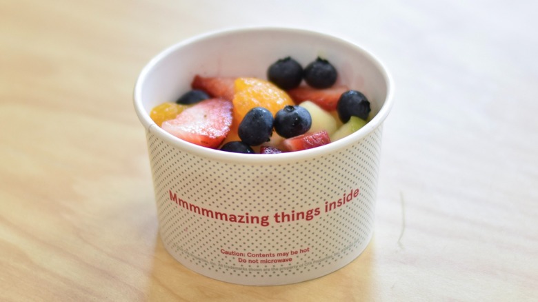 A cup of fresh fruit from Chick-fil-A on a wooden table