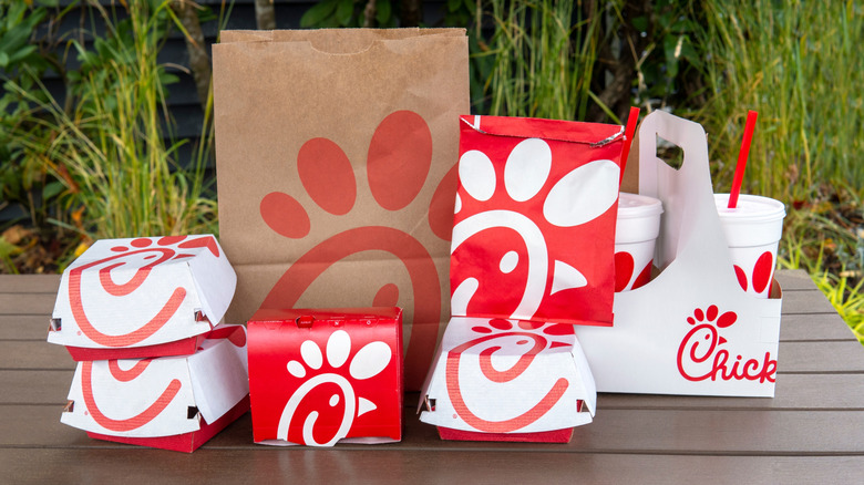 outdoor table full of Chick-fil-A branded bags and items