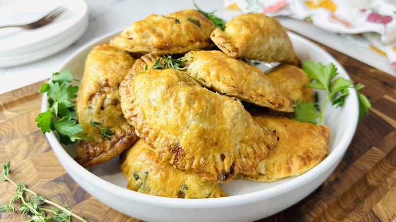 small semicircular baked pies on a white plate
