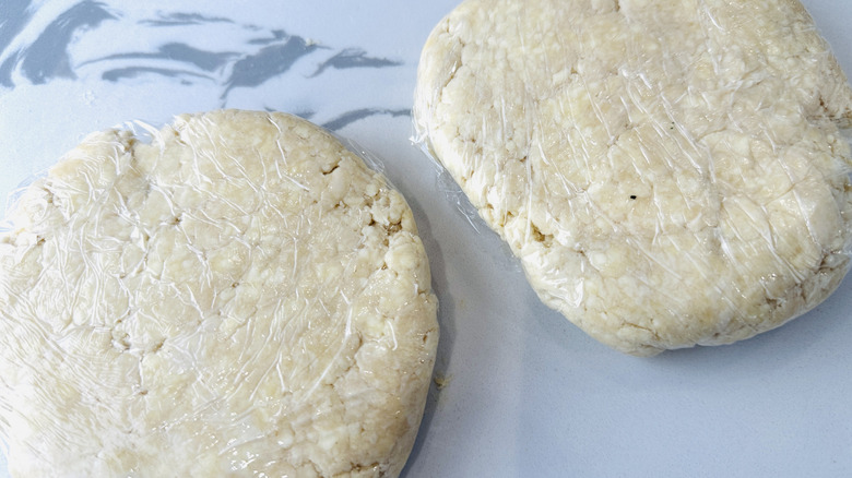 two flattened mounds of dough wrapped in plastic
