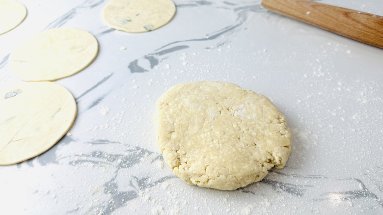 mound of dough next to several flattened dough circles