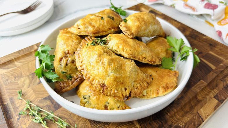 small semicircular baked pies on a white plate