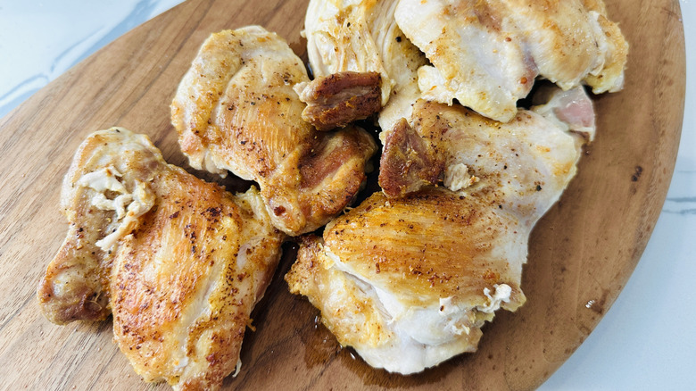 cooked chicken on a wooden board