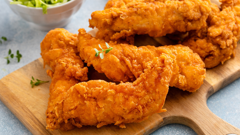 Chicken tenders on wooden board