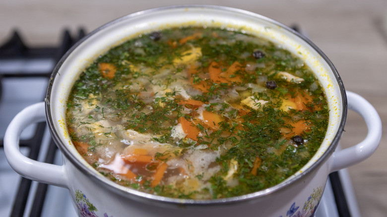 A decorative stockpot full of fresh vegetable soup.