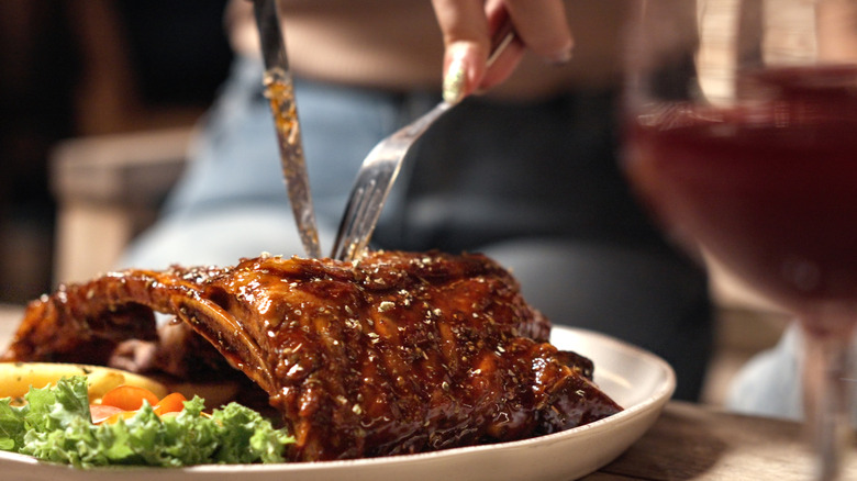 Fork and knife going into ribs on a plate.