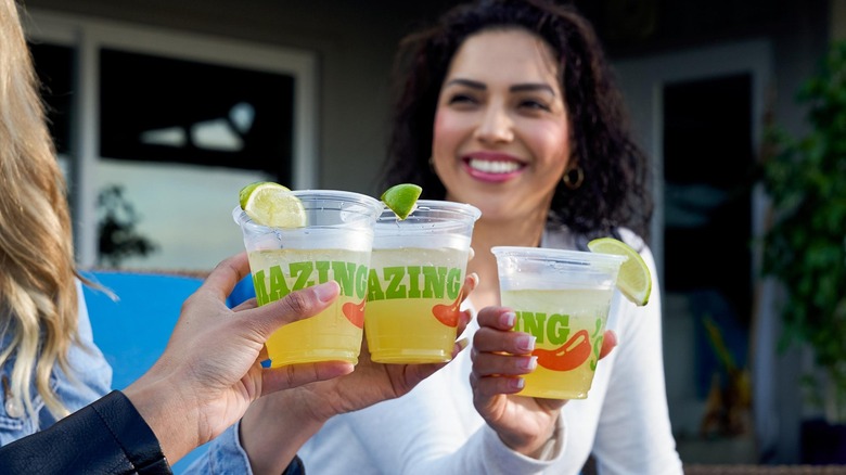 Group of people clinking takeout drinks form Chili's