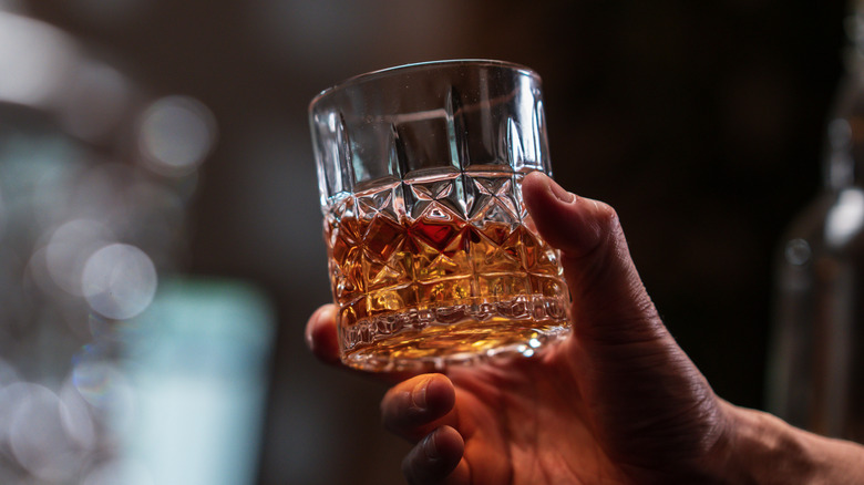 Person holding glass of whiskey