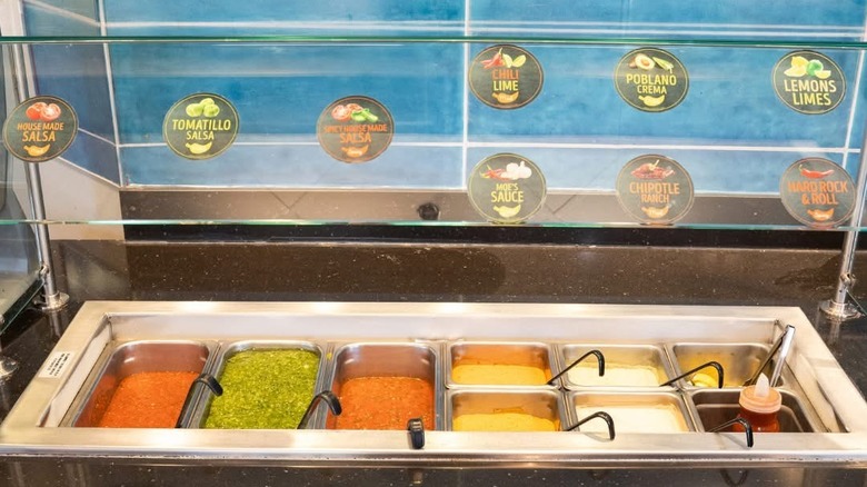 The salsa bar at Moe's with various sauces in self-service containers