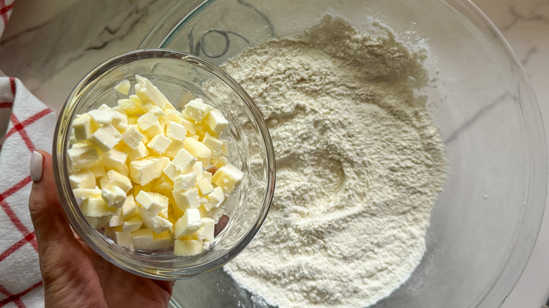 hand adding butter to mix