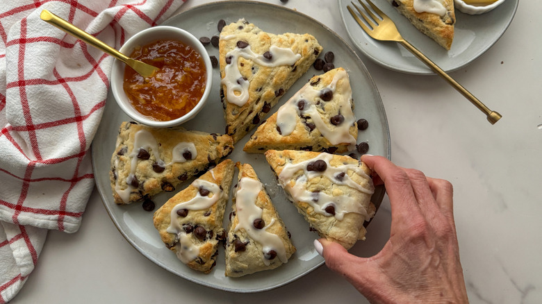 hand taking a scone from plate