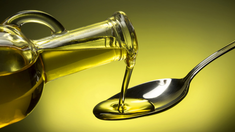 Close-up of olive oil being poured onto a spoon.