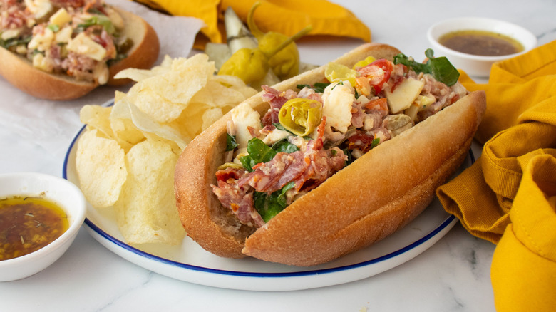 Side shot of two hoagie rolls stuffed with chopped Italian sandwich ingredients