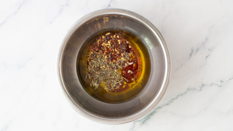 Italian dressing ingredients in a medium metal bowl