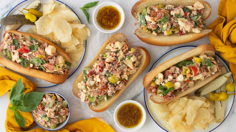 Overhead image of several hoagie rolls stuffed with chopped Italian sandwich ingredients