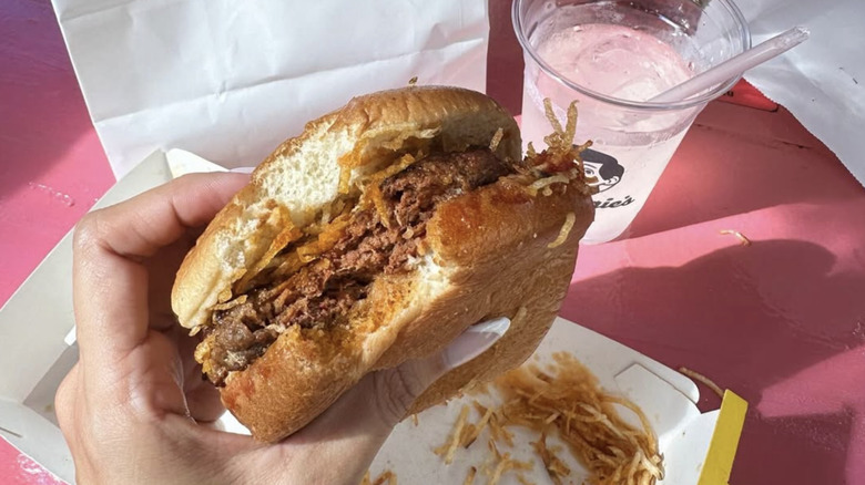 A hand holds a frita from Chuggie's in Miami