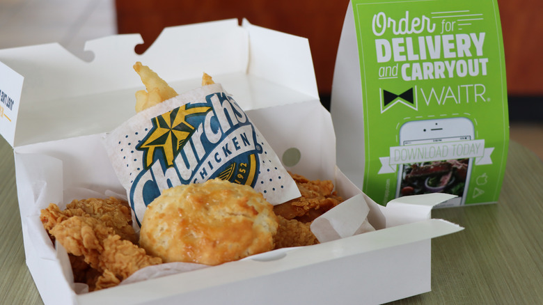 A box of chicken, fries, and a biscuit from Church's Chicken.