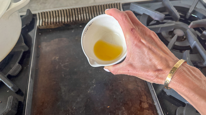 hand adding butter to griddle