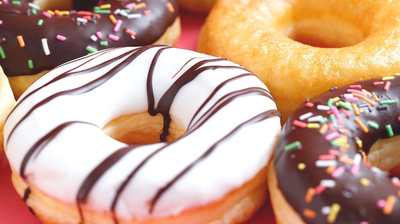 Closeup of donuts covered in thick, white and chocolate frosting