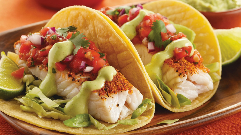 White fish tacos on corn tortillas with pico de gallo and green crema