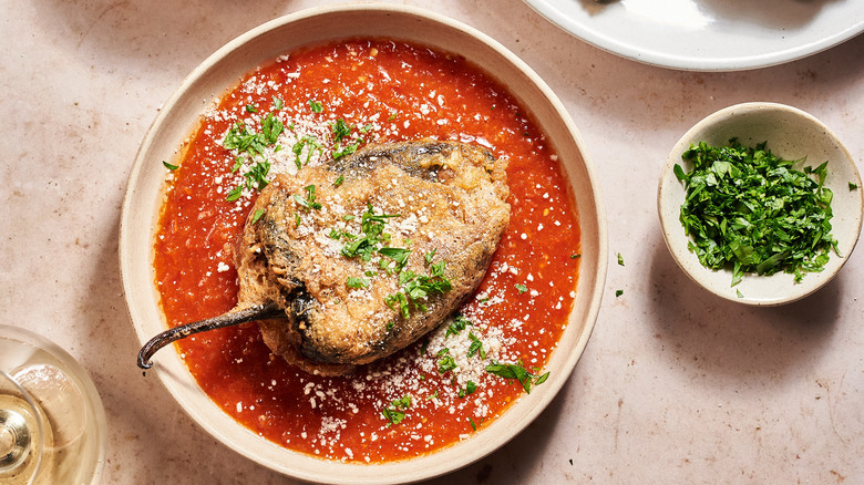 chiles rellenos on a plate with salsa