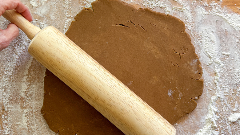 Rolling pin rolling out gingerbread cookie dough