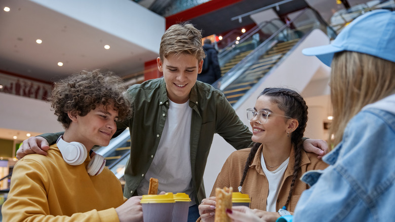 Friends gather in a mall food court.