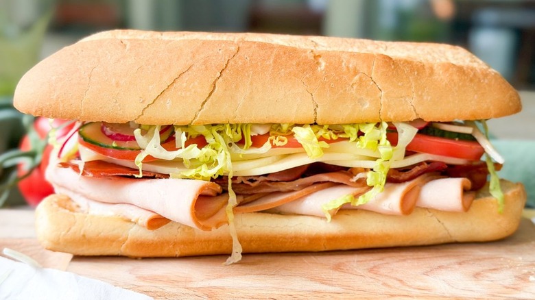 Side view of classic Italian-ish club sub sandwich on cutting board