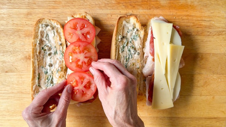 Adding sliced tomato to classic Italian-ish club sub sandwich
