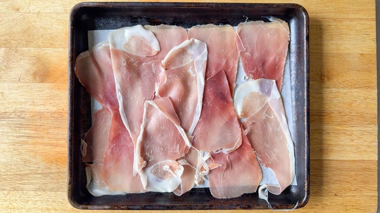 Prosciutto slices in single layer on parchment-lined baking sheet