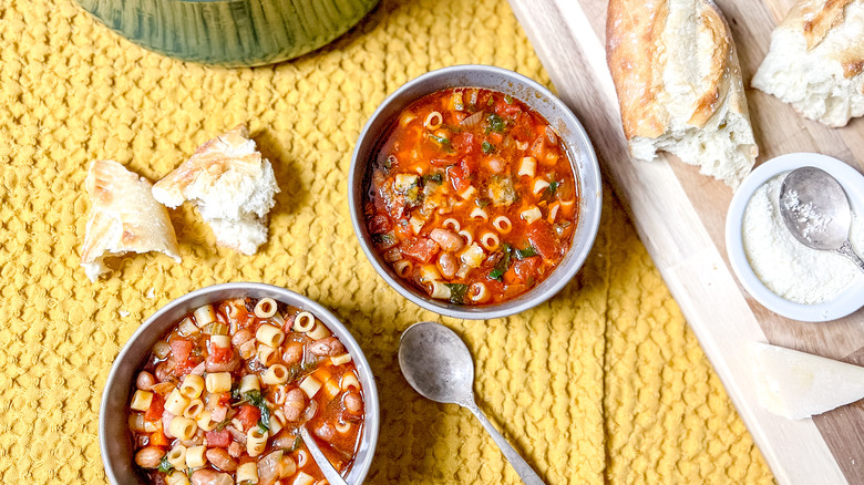 Classic pasta e fagioli in bowls with bread on table