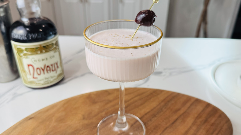 Pink squirrel cocktail garnished with cherry