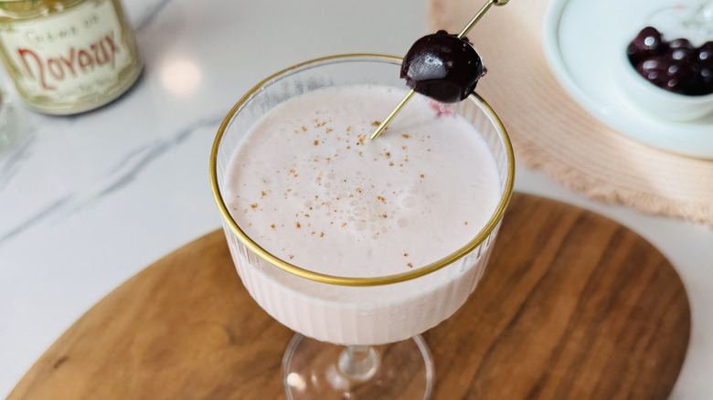 Pink squirrel cocktail garnished with cherry